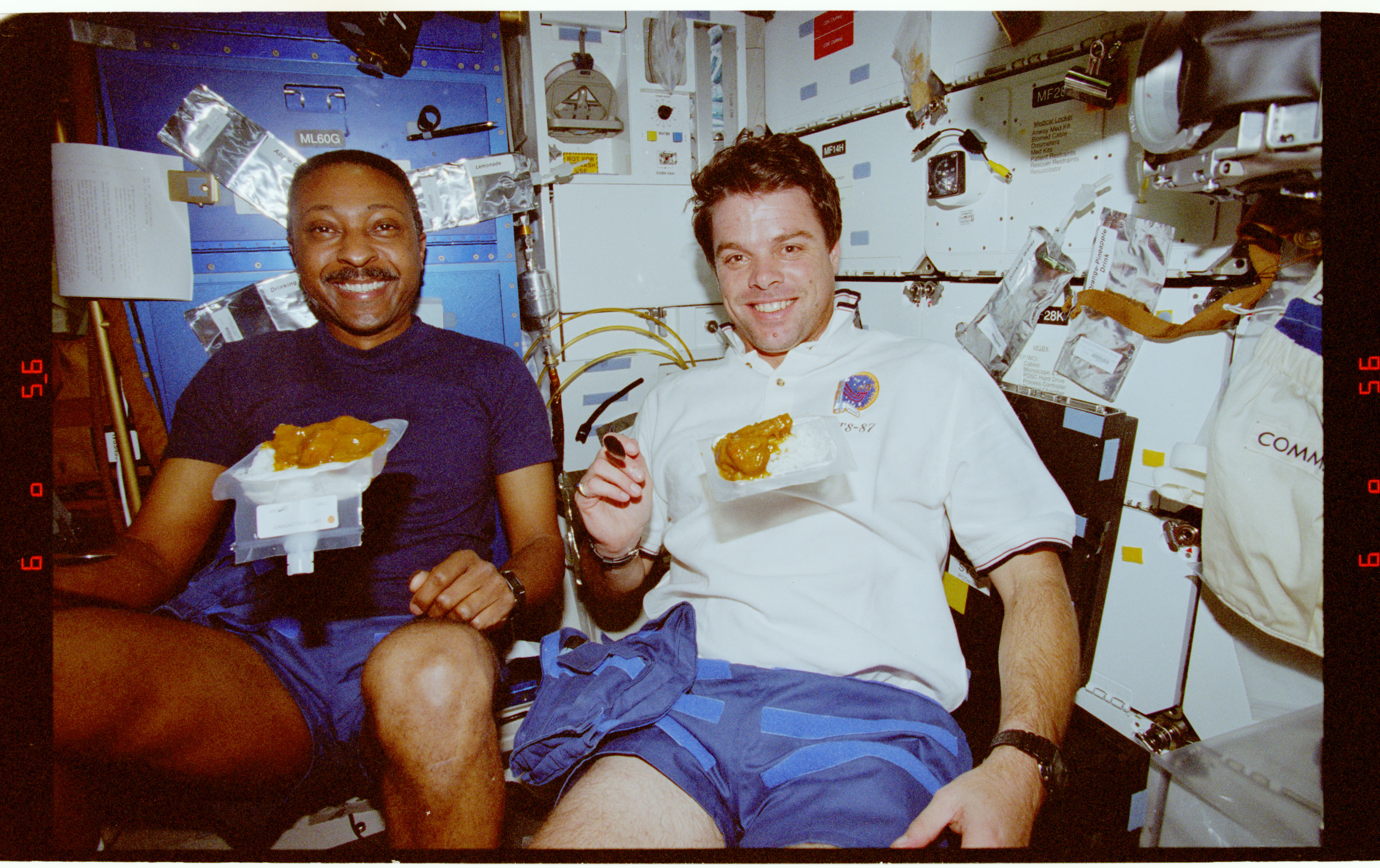 STS087-375-018 - STS-087 - Crewmembers share a meal in the middeck