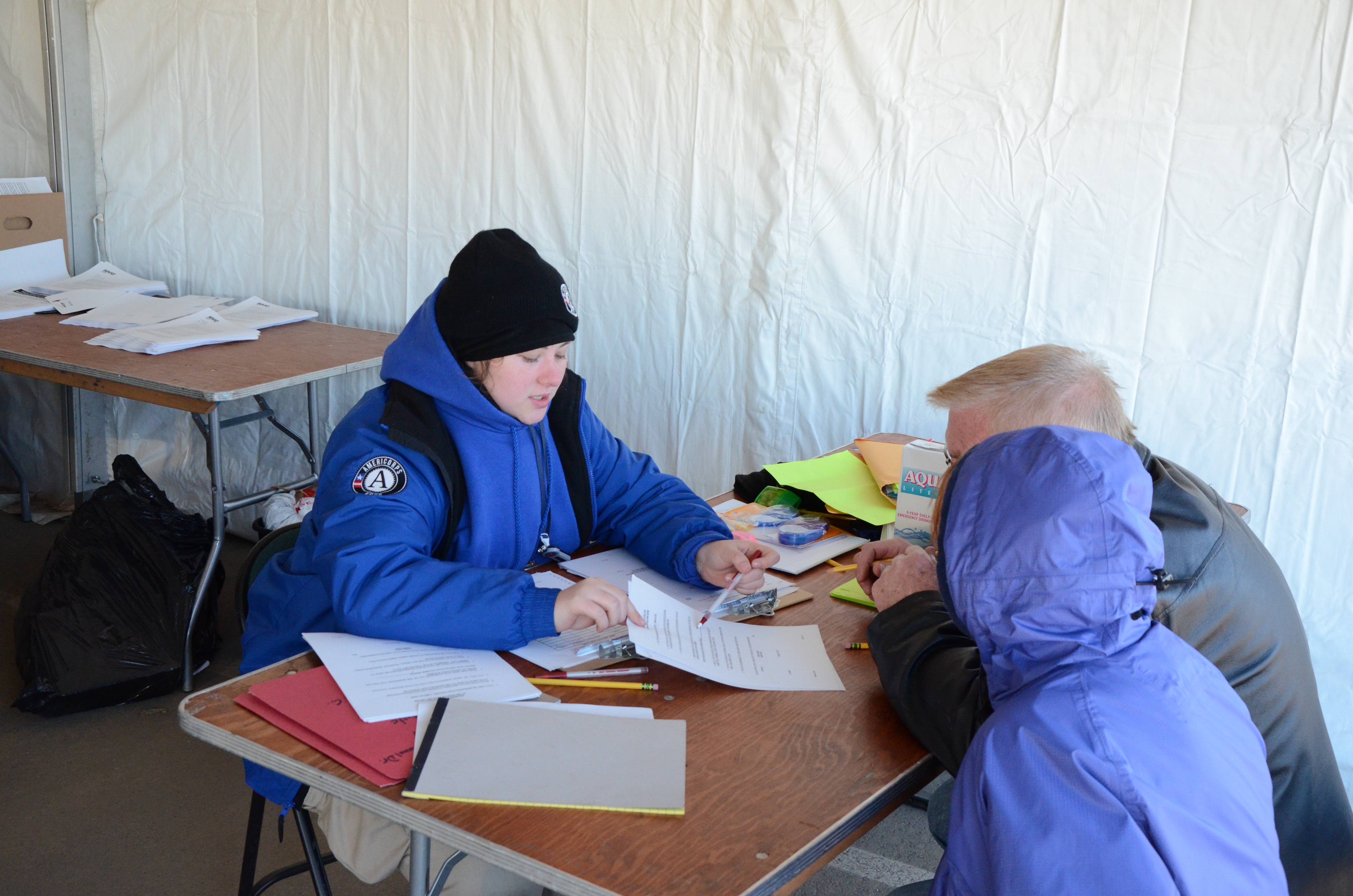 Rockaway, N.Y., Nov. 5, 2012 -- FEMA Corps Member Kristy Bouchard at the reception desk describing the services provided to survivors of Sandy at the Rockaway Disaster Recovery Center. FEMA is working with state and local officials to assist residents who were affected by Hurricane Sandy. Photo by Sean Kerr/FEMA