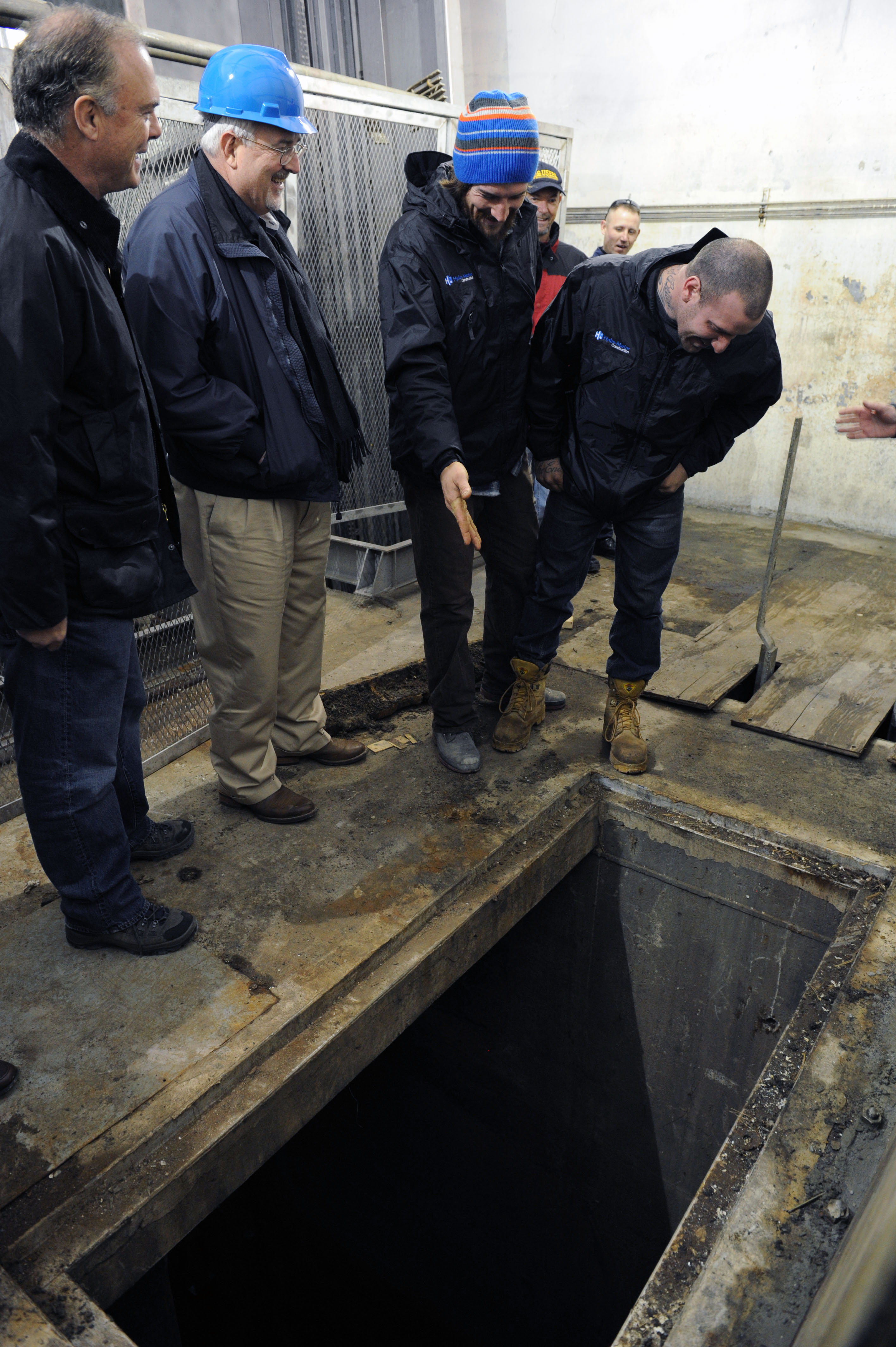 Sayerville, N.J., Nov. 28, 2012 -- FEMA Administrator Craig Fugate, second from left, and Commissioner of NJ Environmental Protection Bob Martin, talk to the two construction divers, Jeremy Irons, second from right, and Ralph Hagen, right, who were instrumental in restoring a gate in the water pumping station when it was flooded with waste water during Hurricane Sandy. The station was flooded and extraordinary efforts were made to restore the station. Jocelyn Augustino/FEMA