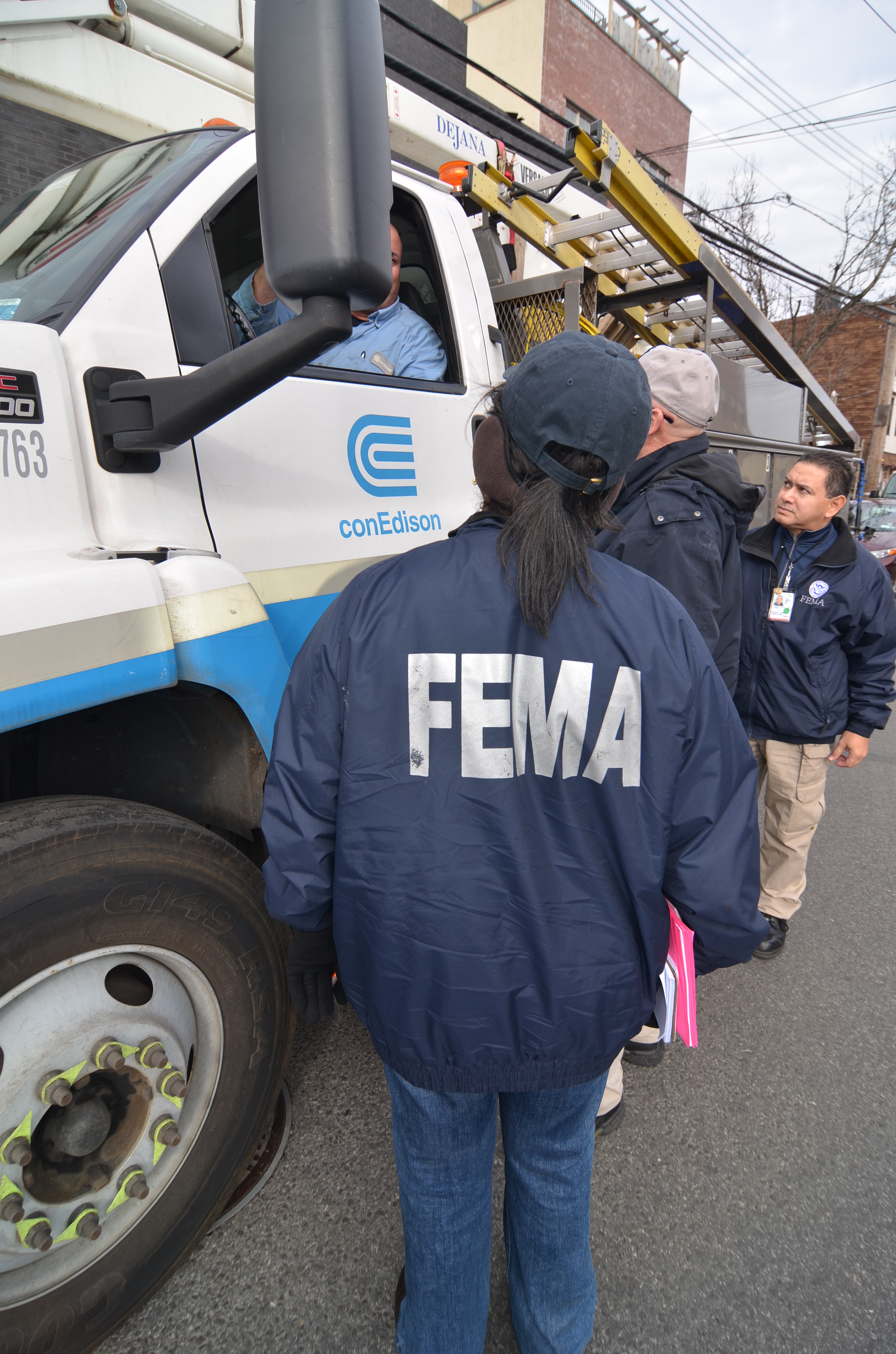 New York City, N.Y., Dec. 11, 2012 -- FEMA Community Relations employees discuss the restoration of electric service in the Red Hook area of Brooklyn with employees of NYC's Con Edison electric company. The repair of old electrical infrastructure in the New York City area has frustrated residents and business people in the aftermath of Hurricane Sandy. Walt Jennings/FEMA