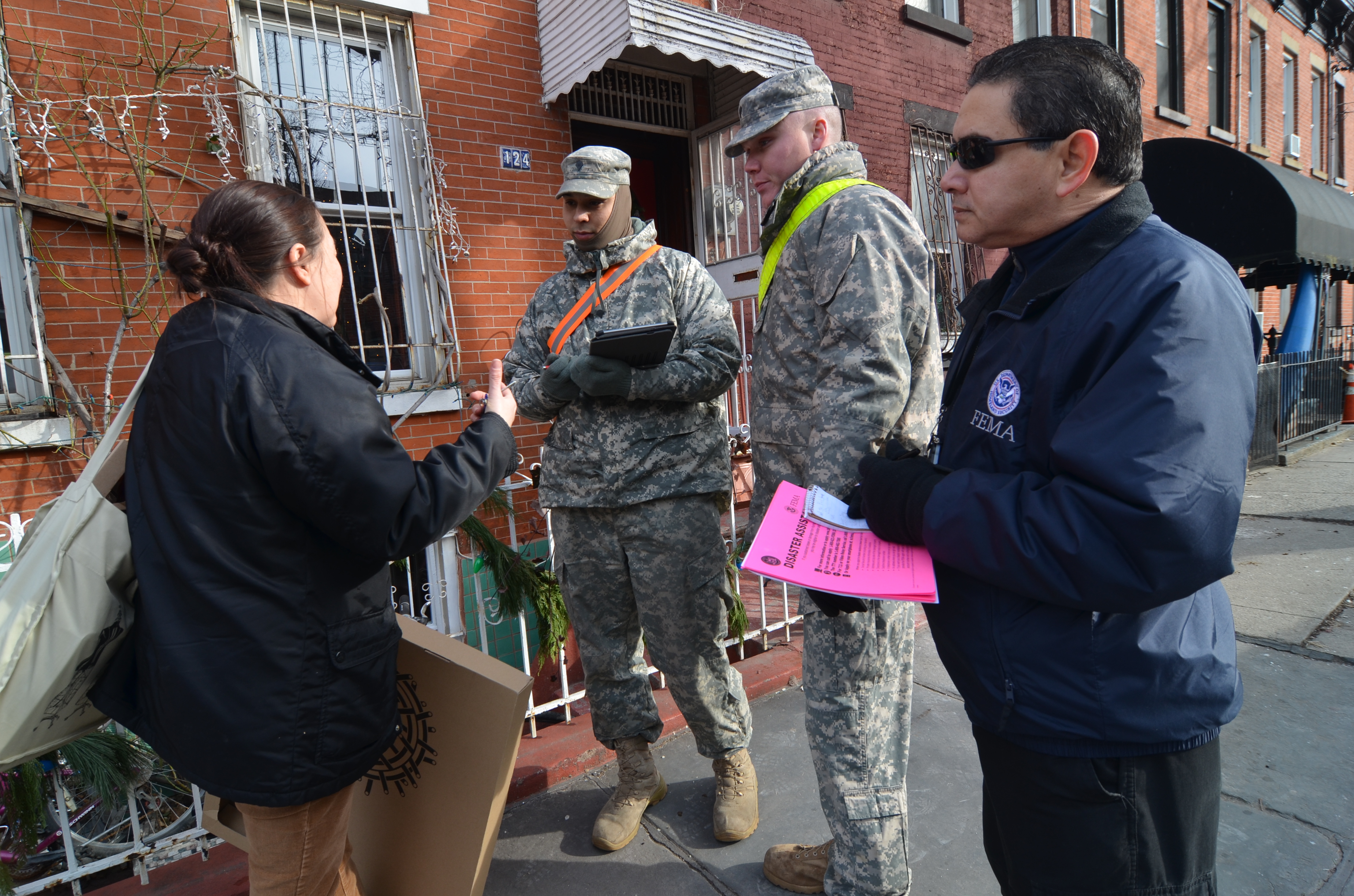New York City, N.Y., Jan. 2, 2013 -- Over 30 members of the New York National Guard walked door-to-door in New York to assist the survivors of Hurricane Sandy. National Guardsmen Specialist Jones of the HSC642-ASB unit, and Specialist Pimiental, Bravo Company 642 AB, took part in Operation "Task Force Sandy" by walking along Pioneer Street in the Red Hook area of Brooklyn. Members of their unit are working in the area completing ΓÇ£wellness checks,ΓÇ¥ to see if citizens have electricity and heat. Resident with electricity but no heat, are provided a portable heater. Walt Jennings/FEMA