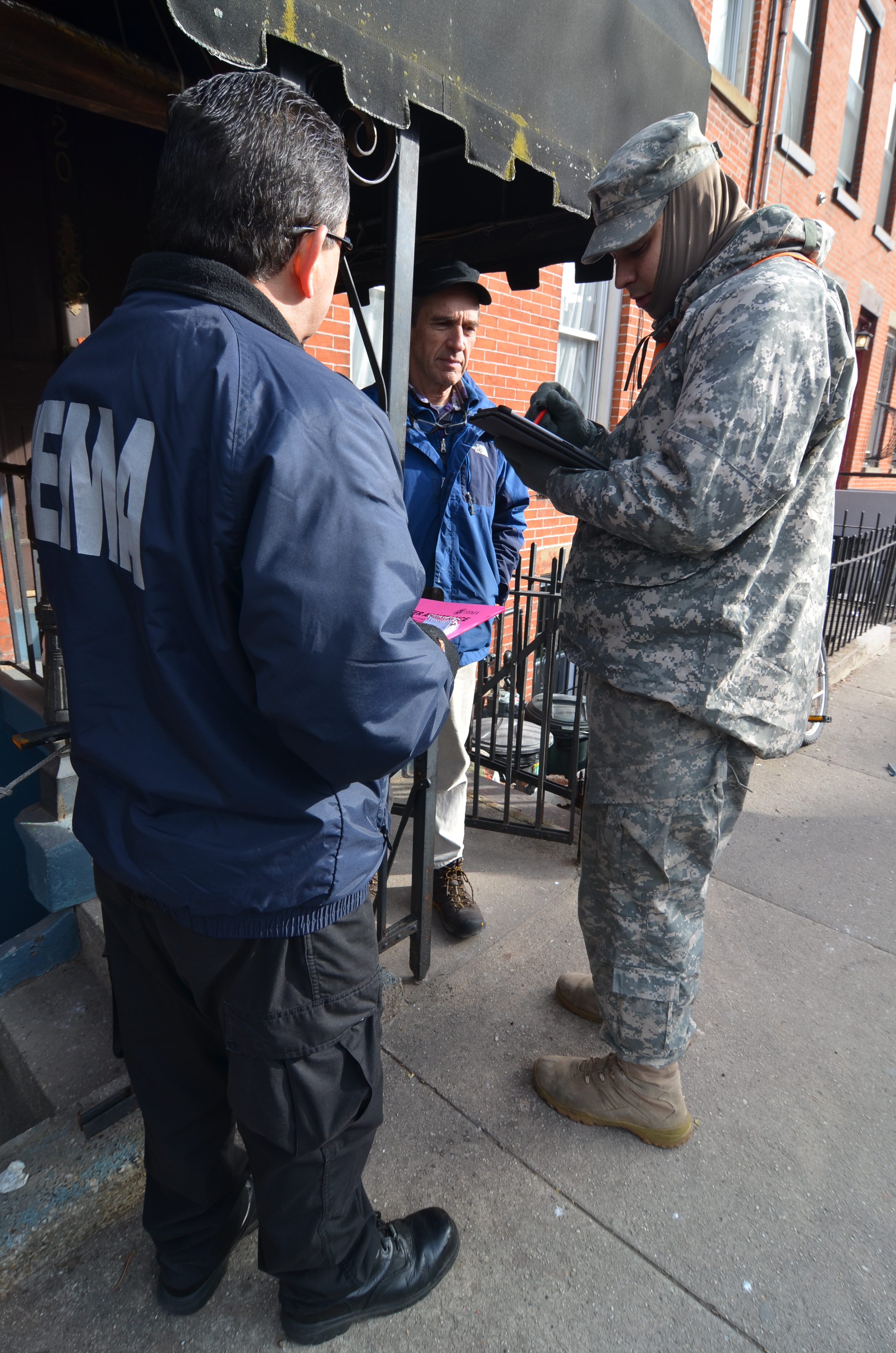 New York City, N.Y., Jan. 2, 2013 -- Over 30 members of the New York National Guard walked door-to-door in New York to assist the survivors of Hurricane Sandy. National Guardsmen Specialist Jones of the HSC642-ASB unit, and Specialist Pimiental, Bravo Company 642 AB, took part in Operation "Task Force Sandy" by walking along Pioneer Street in the Red Hook area of Brooklyn. Members of their unit are working in the area completing ΓÇ£wellness checks,ΓÇ¥ to see if citizens have electricity and heat. Resident with electricity but no heat, are provided a portable heater. Walt Jennings/FEMA